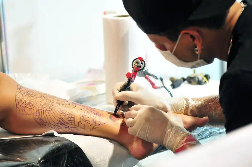Tattoo artist preparing studio and documents for 2027 Tattoo Act compliance
