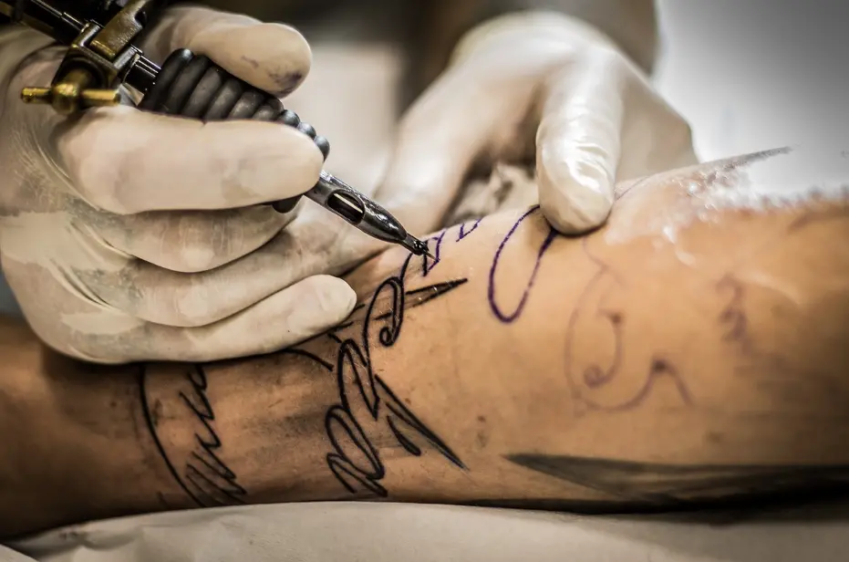 Licensed tattoo artist performing hygienic procedure under professional tattoo licensing standards